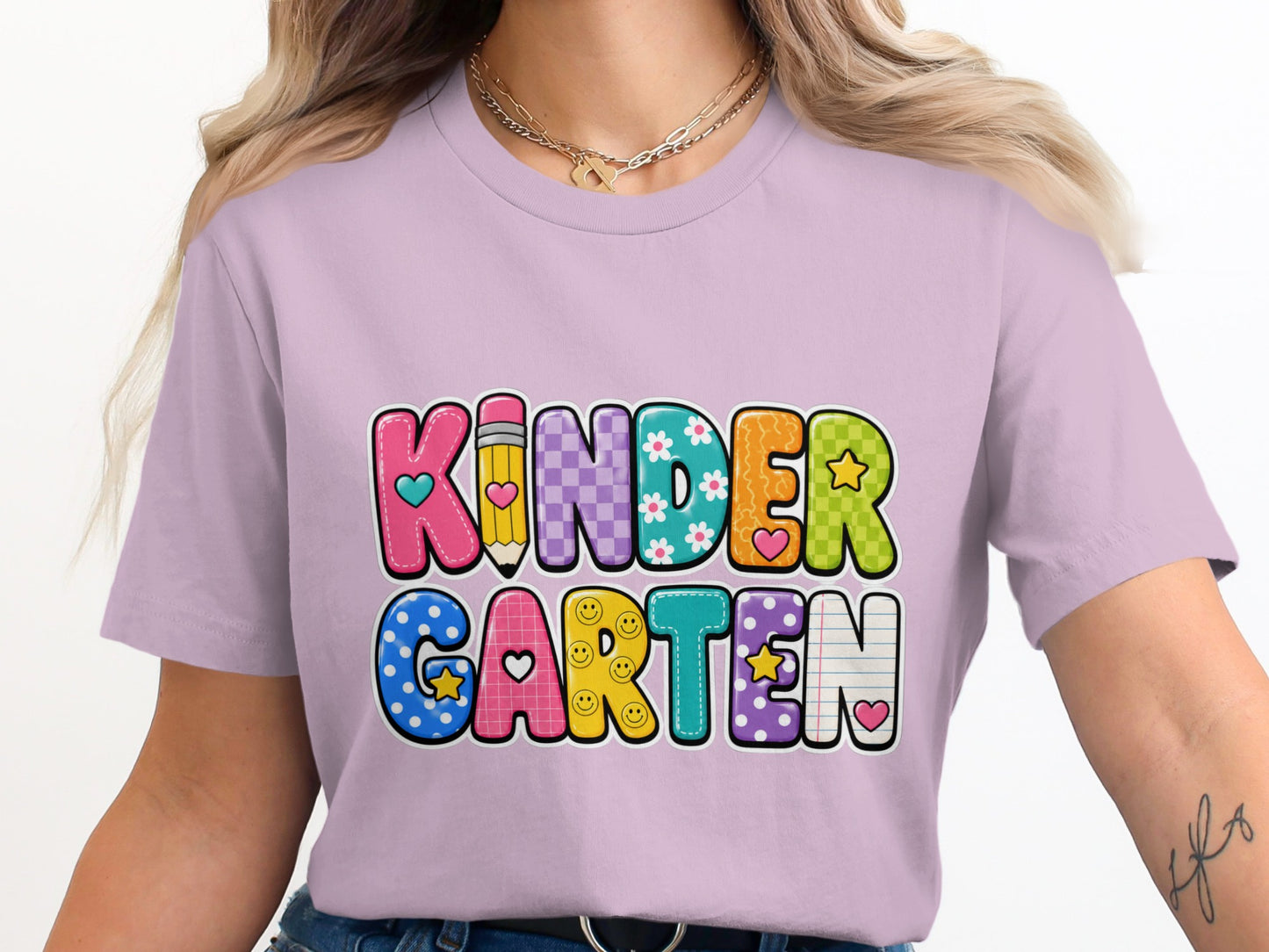Lavender t-shirt with colorful "Kindergarten" text design featuring stars, flowers, and smiley faces.