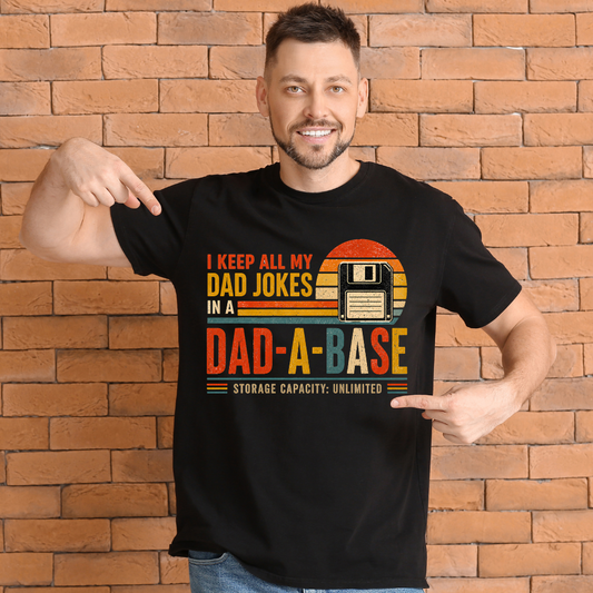 Man wearing a black t-shirt with a humorous dad design in front of a brick wall.