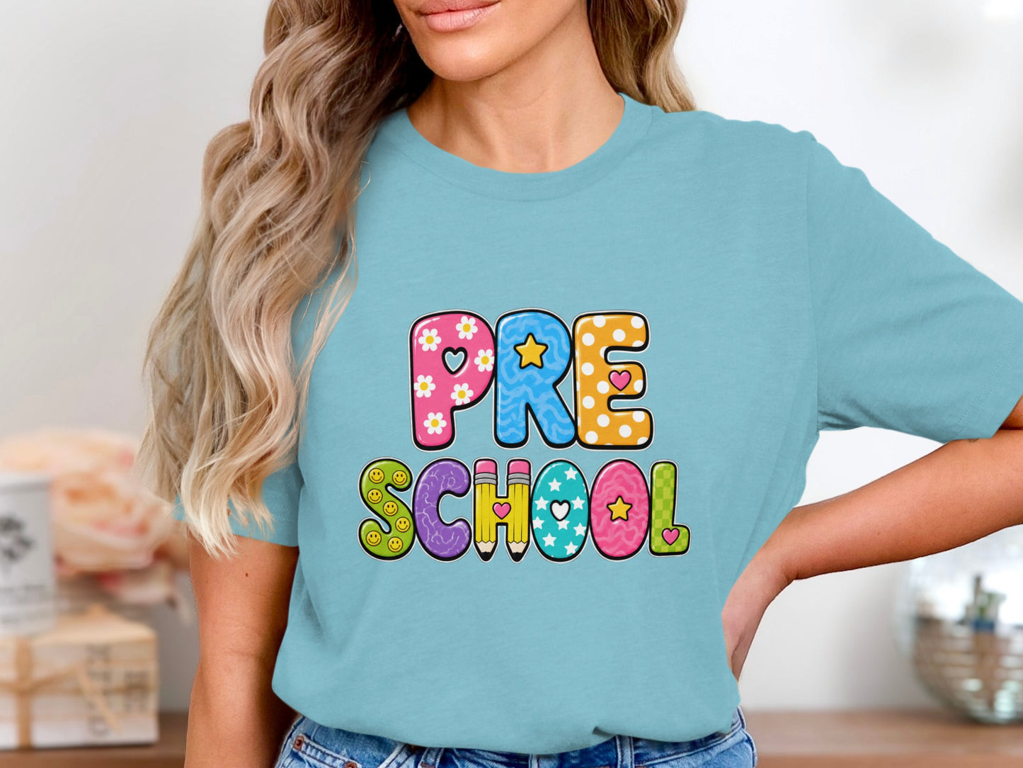 Light blue t-shirt with colorful "PRE SCHOOL" text and playful designs.