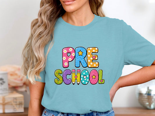 Light blue t-shirt with colorful "PRE SCHOOL" text and playful designs.