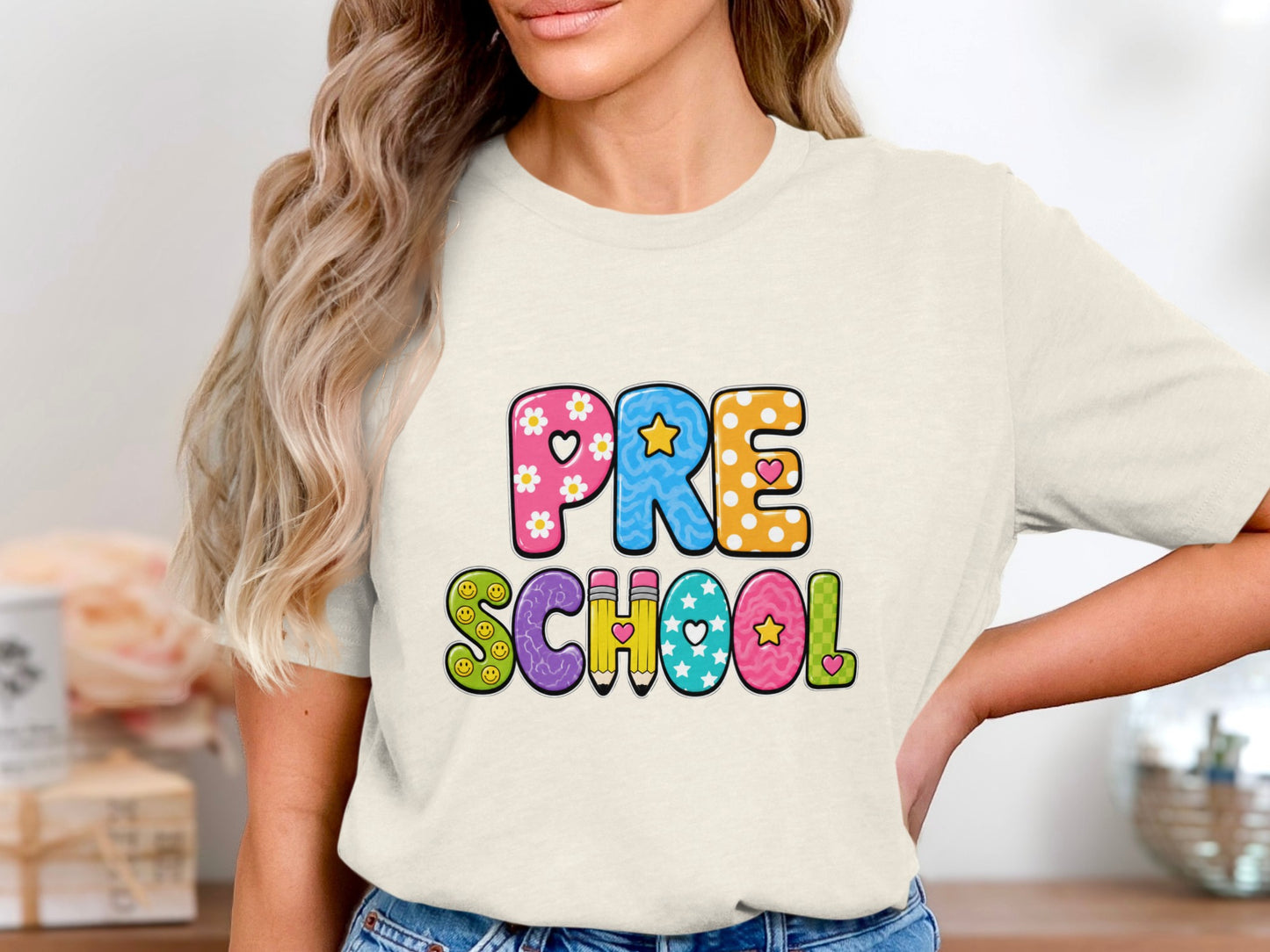 Cream t-shirt with "PRE SCHOOL" text in colorful, patterned letters.