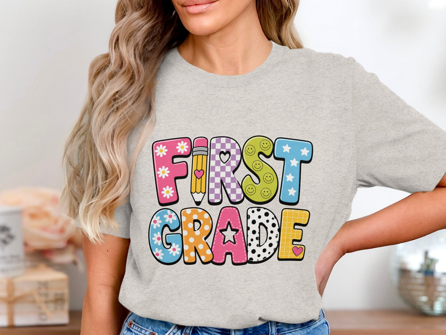 T-shirt with "FIRST GRADE" text in colorful, illustrated letters.