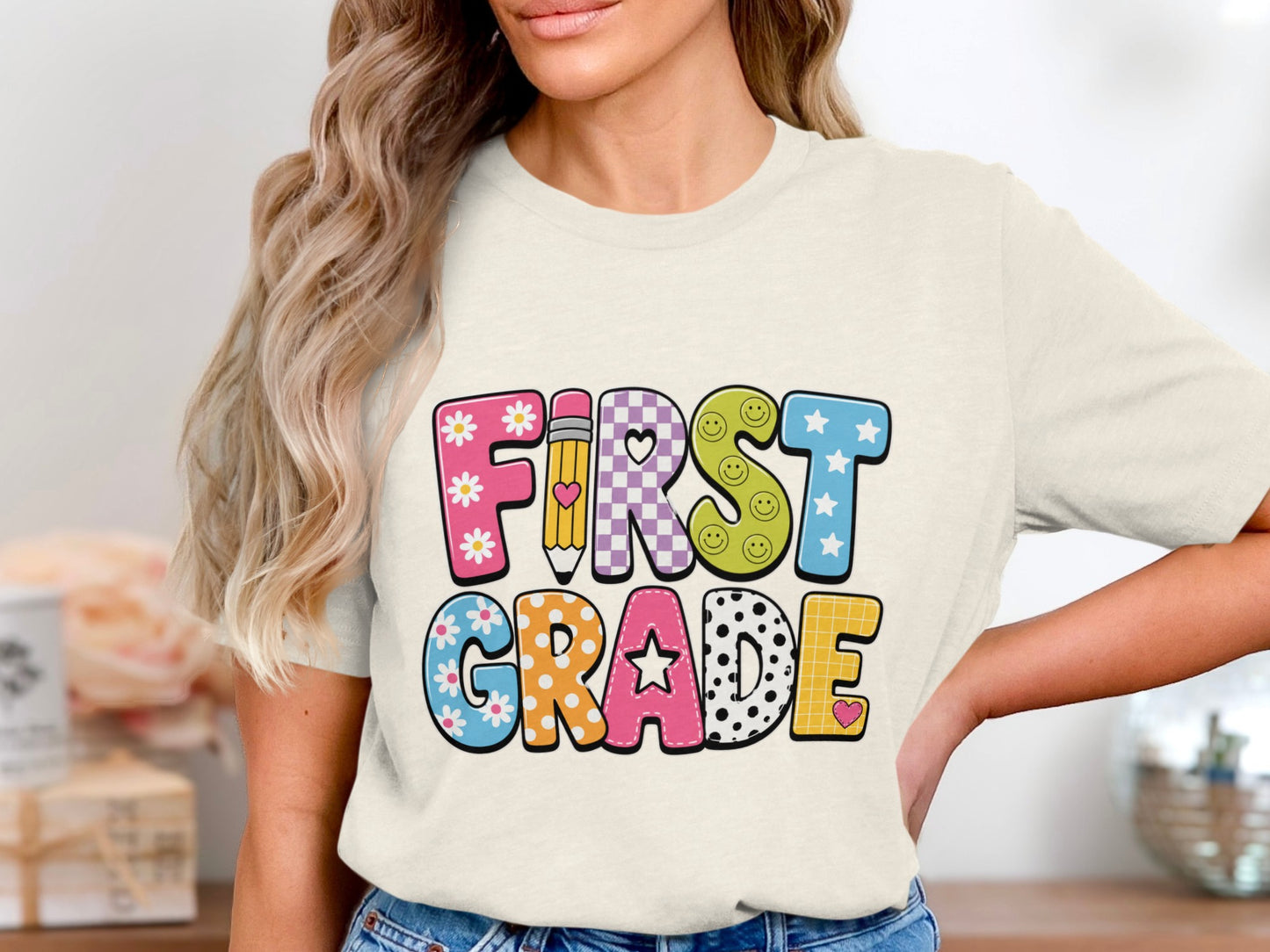 Cream t-shirt with "First Grade" text in colorful, patterned letters.