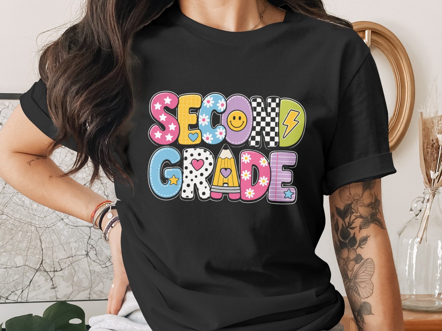 Second Grade title design with colorful letters and school icons on a black t-shirt.