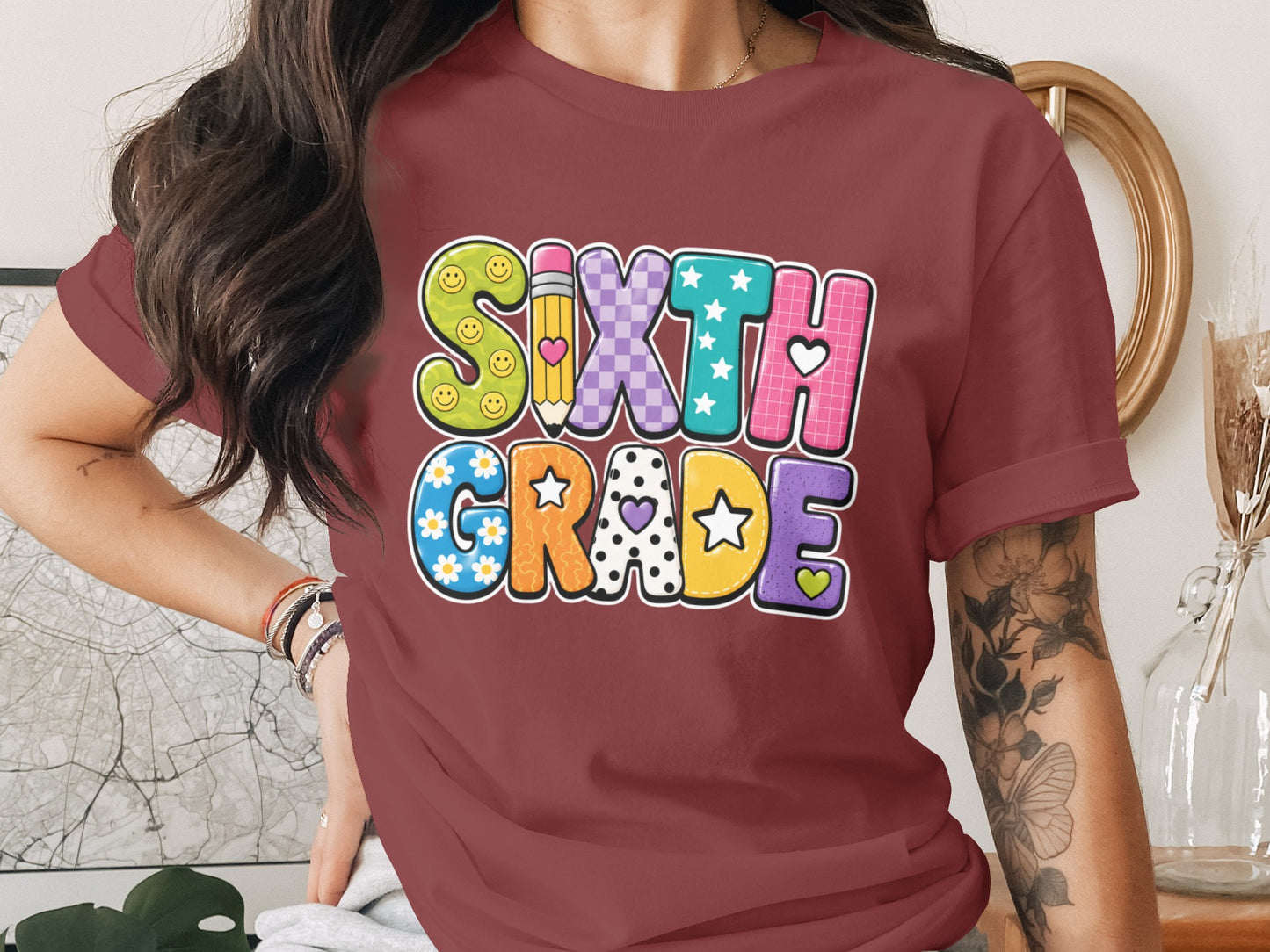 Maroon t-shirt with colorful "SIXTH GRADE" text in cartoon style.