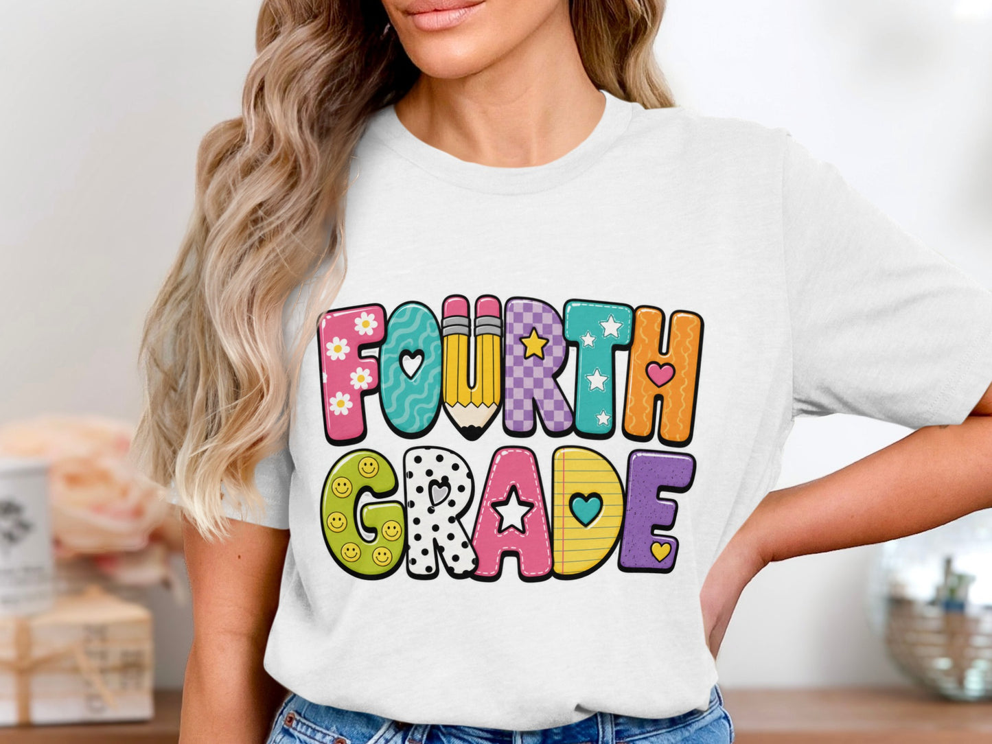 White t-shirt with colorful "FOURTH GRADE" text featuring hearts, flowers, and pencils.