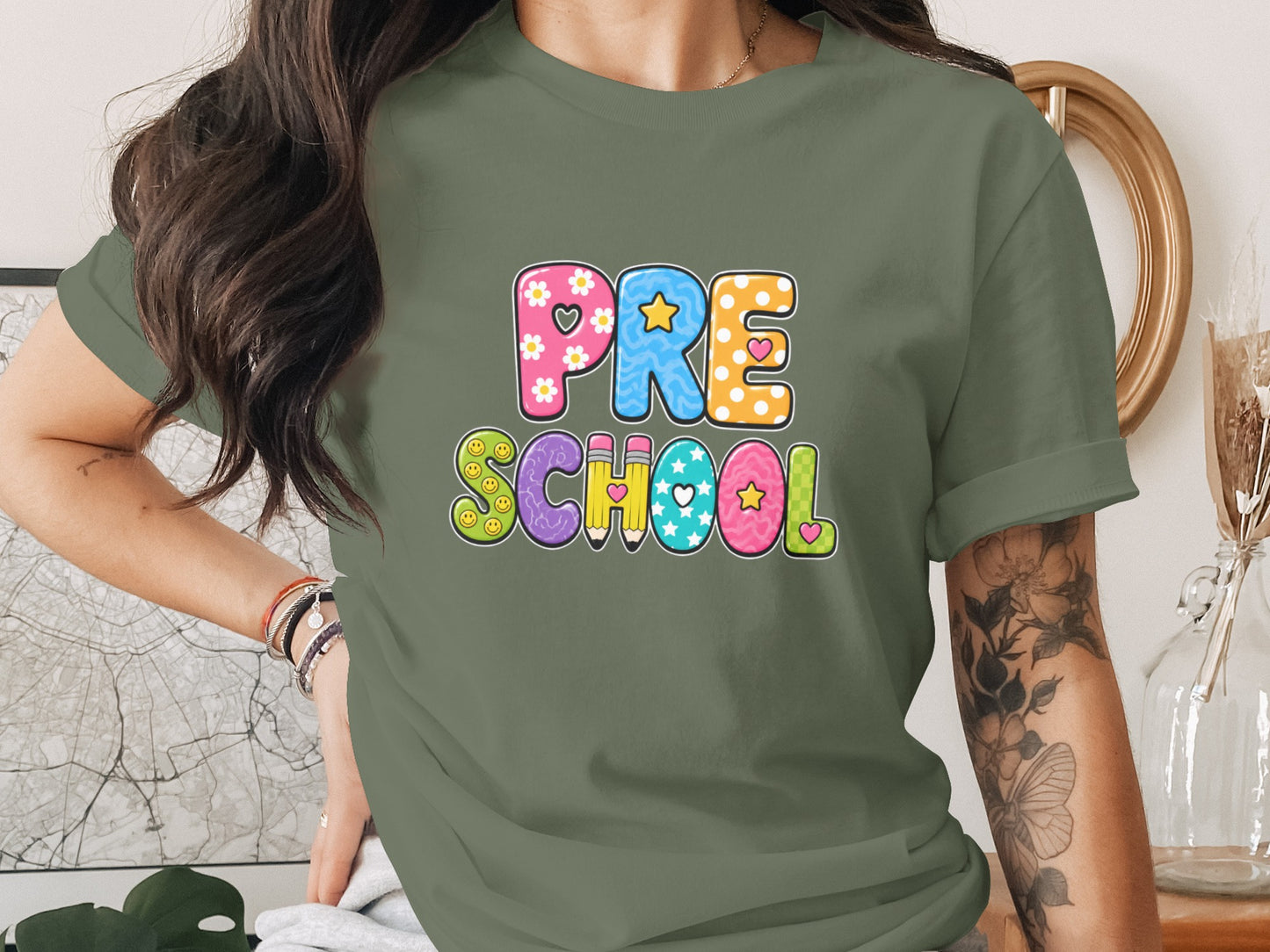Green t-shirt with "PRE SCHOOL" text in colorful, patterned letters.