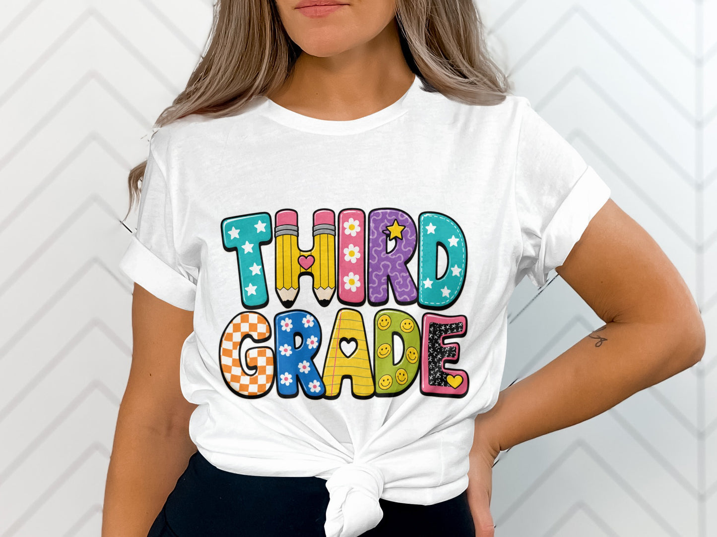 White t-shirt with "THIRD GRADE" text in colorful, patterned bubble letters.