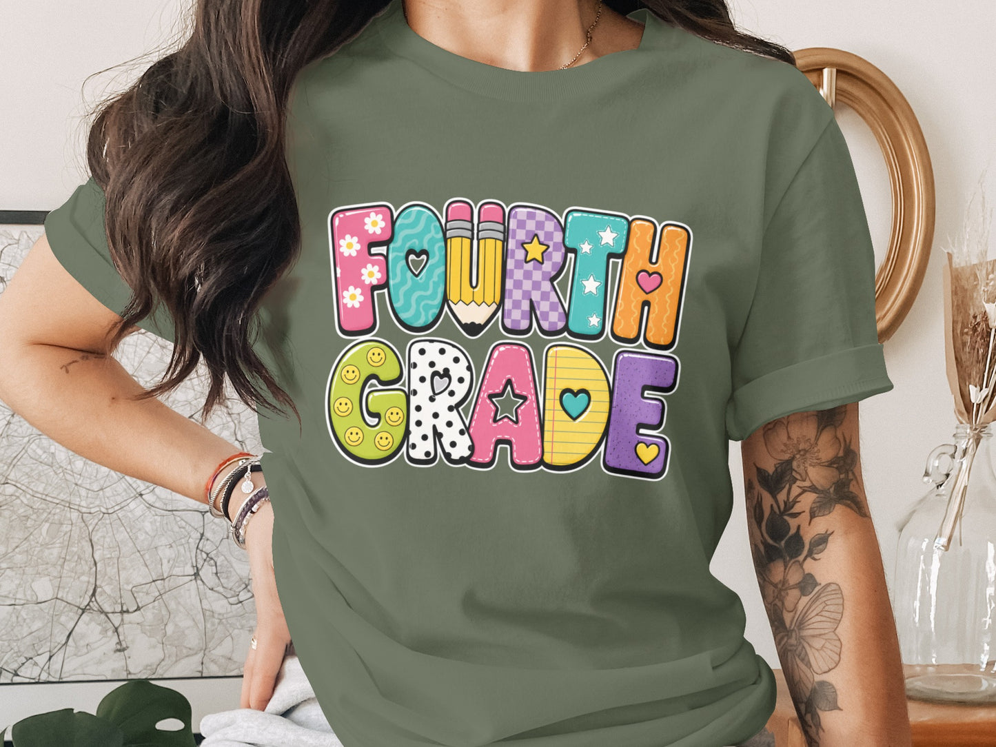 Green t-shirt featuring colorful "Fourth Grade" text with school motifs.