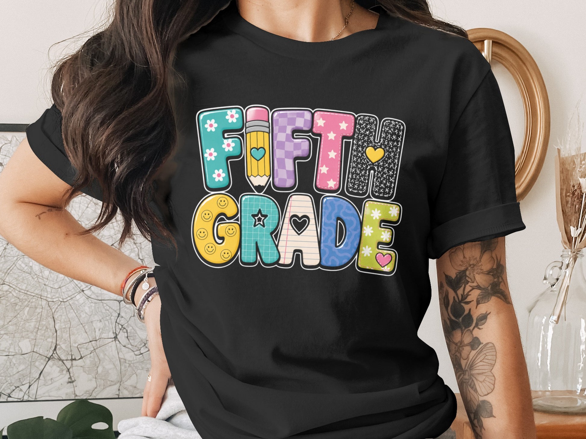Black t-shirt with "Fifth Grade" text in colorful, patterned letters.