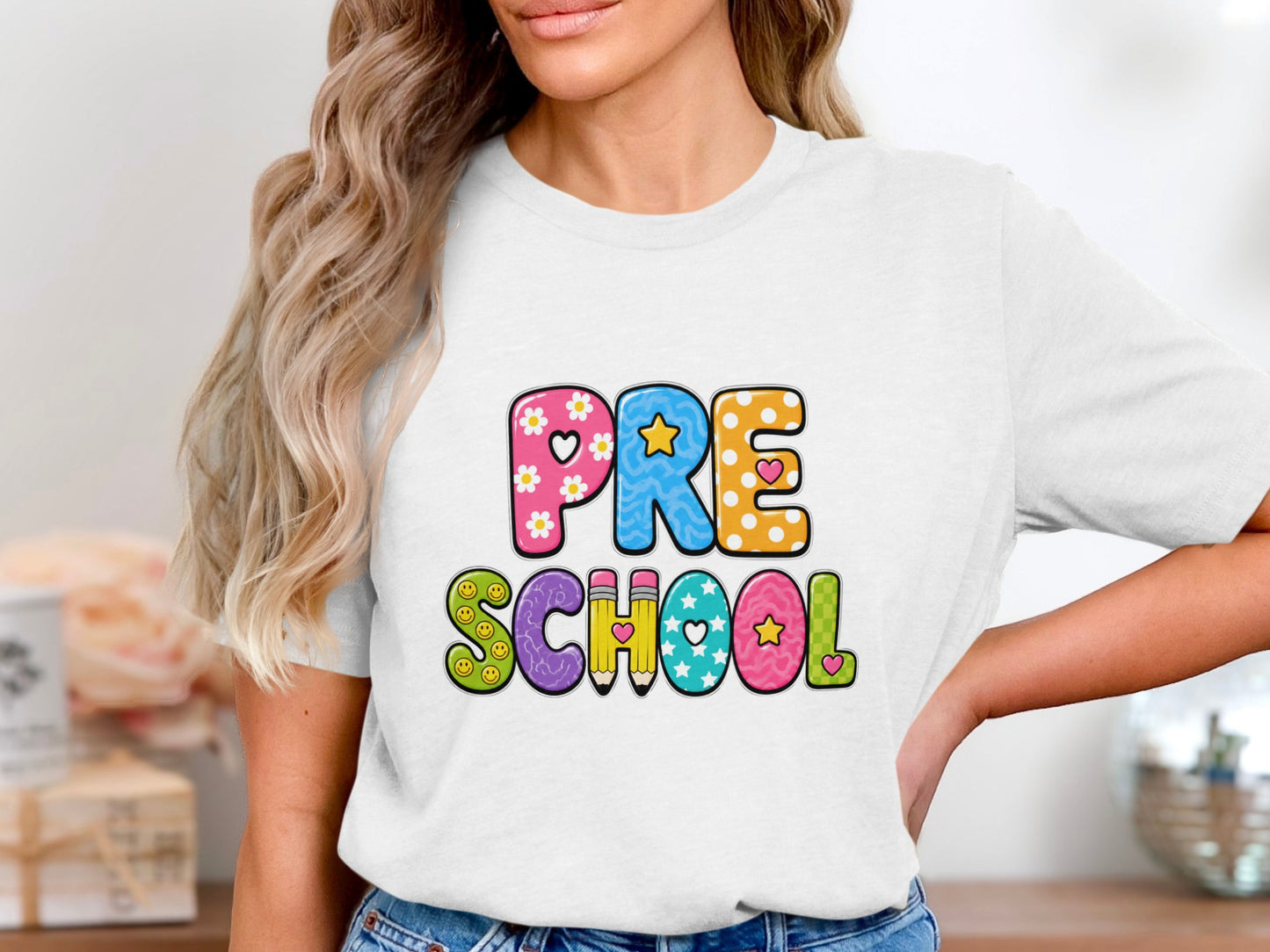 White t-shirt with colorful "PRE SCHOOL" text made of fun patterns.