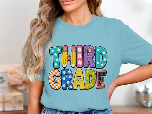 Light blue t-shirt with "THIRD GRADE" in colorful, patterned block letters.
