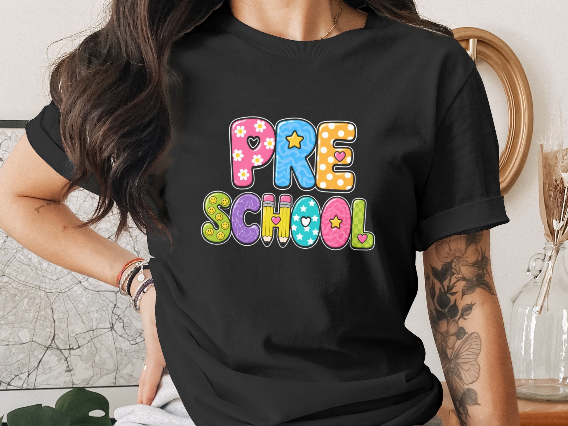 Black t-shirt with colorful "PRE SCHOOL" text and playful patterns.