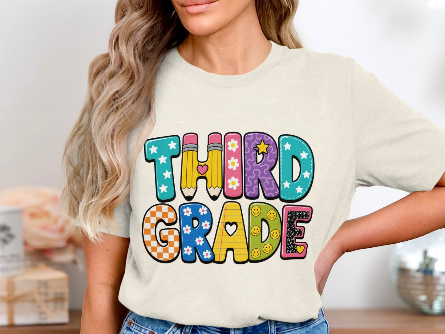 "Third Grade" text with colorful, patterned letters on a cream shirt.