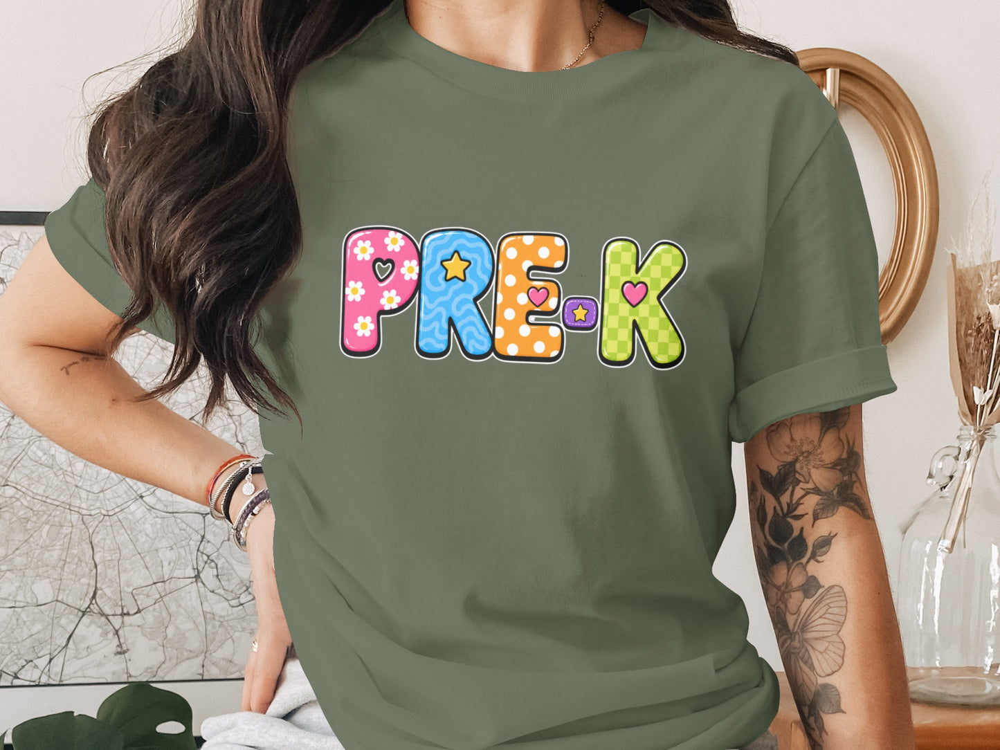 Green t-shirt with colorful "PRE-K" lettering featuring playful patterns and hearts.