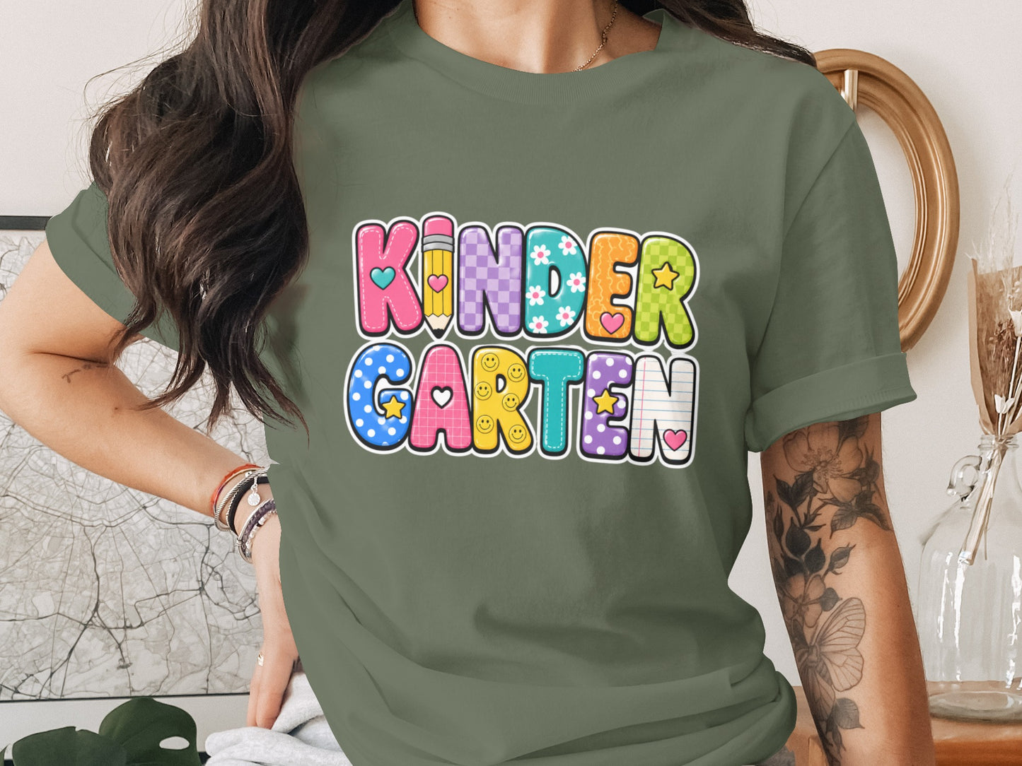 Green t-shirt with "KINDER GARTEN" in colorful, patterned letters.