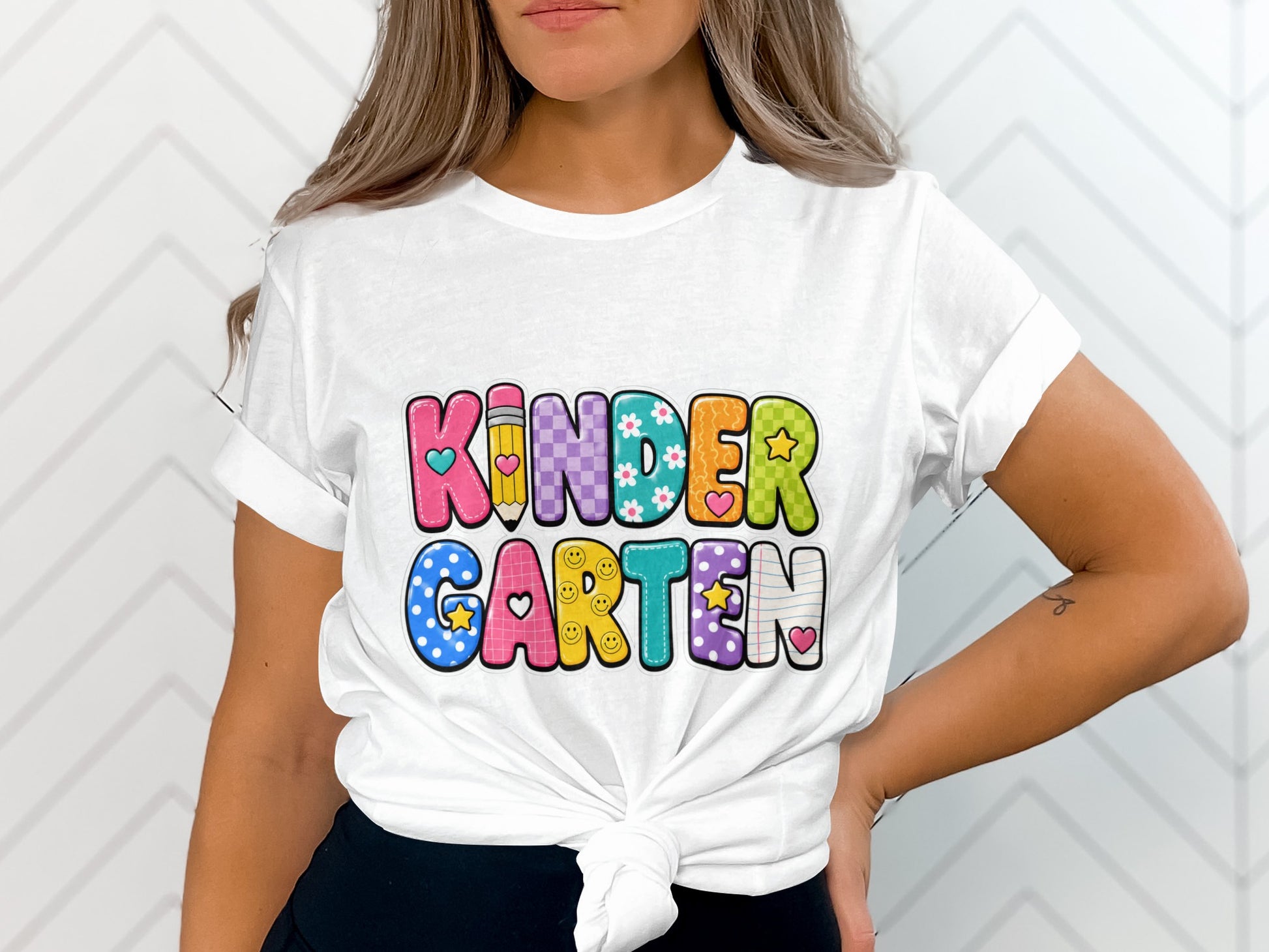 White t-shirt with colorful "Kindergarten" text and school-themed graphics.